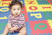 baby girl on letter mat