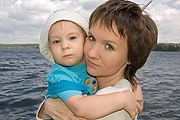 mom baby boy in front of body of water