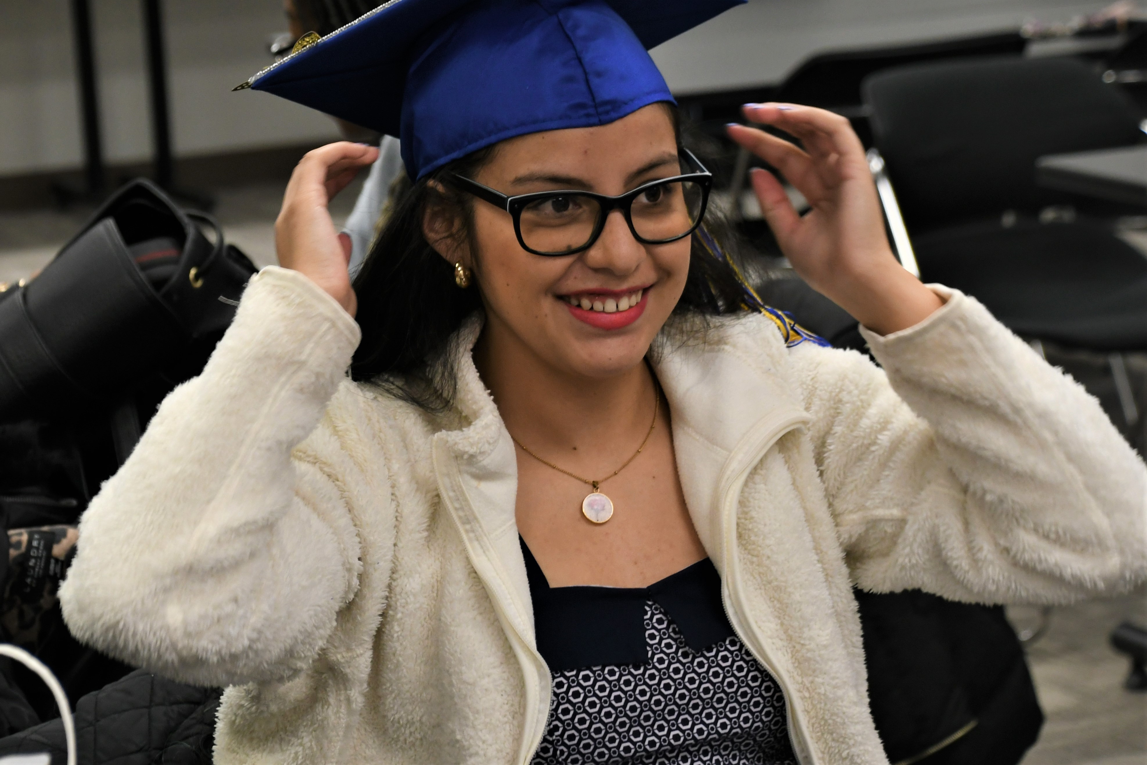 a graduate puttin on her morter board