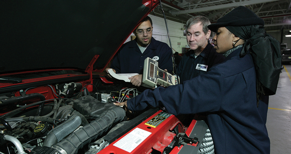 Parolee working on an automaotive engine : Photo