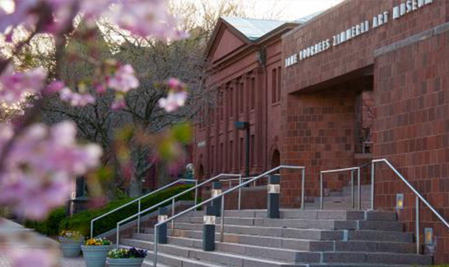 Exterior of museum with pink blossoms in the foreground.