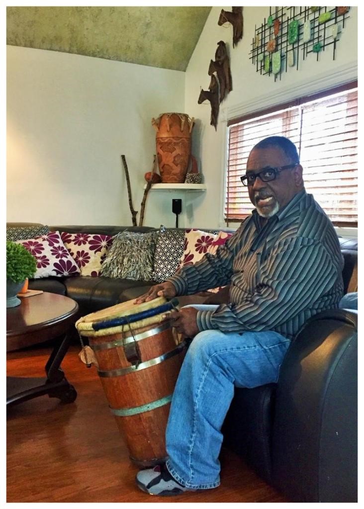 Master Bomba y Plena Practitioner, Nelson Baez, detailing the relic drum he is holding. A contemporary version of the relic can be seen on display in the background.