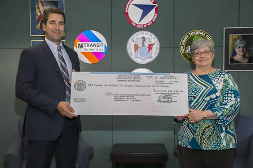 NJDOT Commissioner Diane Gutierrez-Scaccetti presents the I-Bank Vice-Chairman, Robert Briant Jr. with a $22.6 million check from the State Local Aid Infrastructure Fund, marking the launch of the New Jersey Transportation Bank