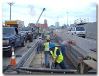 Crews work in the closed off construction zone during weekend work hours. The closed are is comprised of the two center lanes or respective left lanes of the eastbound and westbound lower roadway on Route 139 photo.