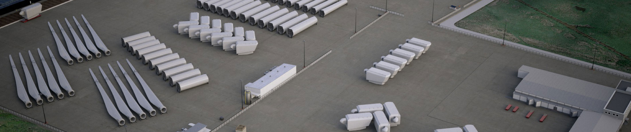 photo contains: Overhead view of manufacturing space with wind turbine blades, nacelles, and other components stored next to a facility. 